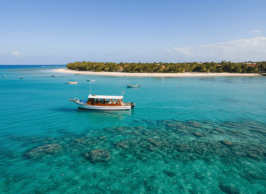 A beautiful small tour boat floating on crystal-clear turquoise Caribbean water near Grand Turk, Turks and Caicos, bright sunny day, stunning blue-green ocean, tropical paradise